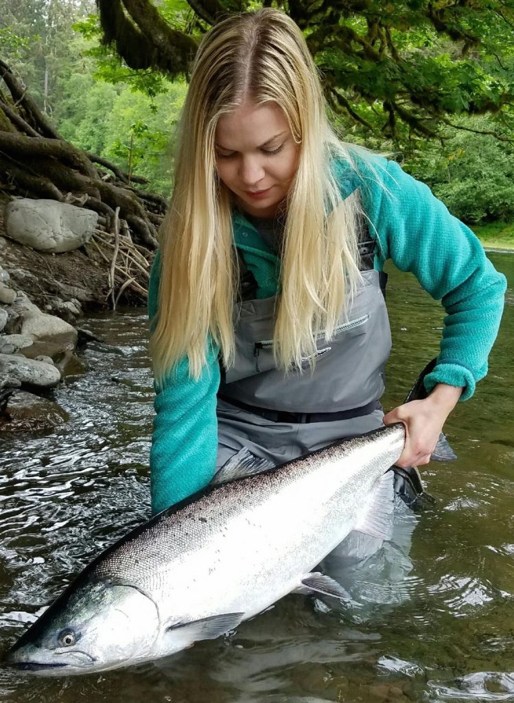 Megan showing Ryan the correct way to hold a salmon